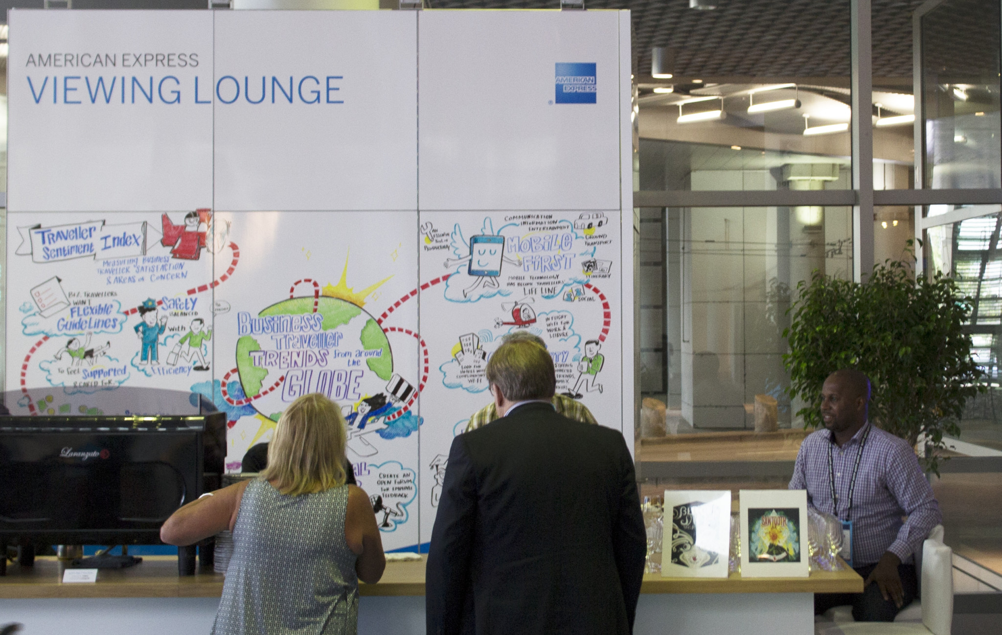 Two conference attendees look at imagethink infographic at amex lounge during global business travel association convention in Denver, CO, 2016.
