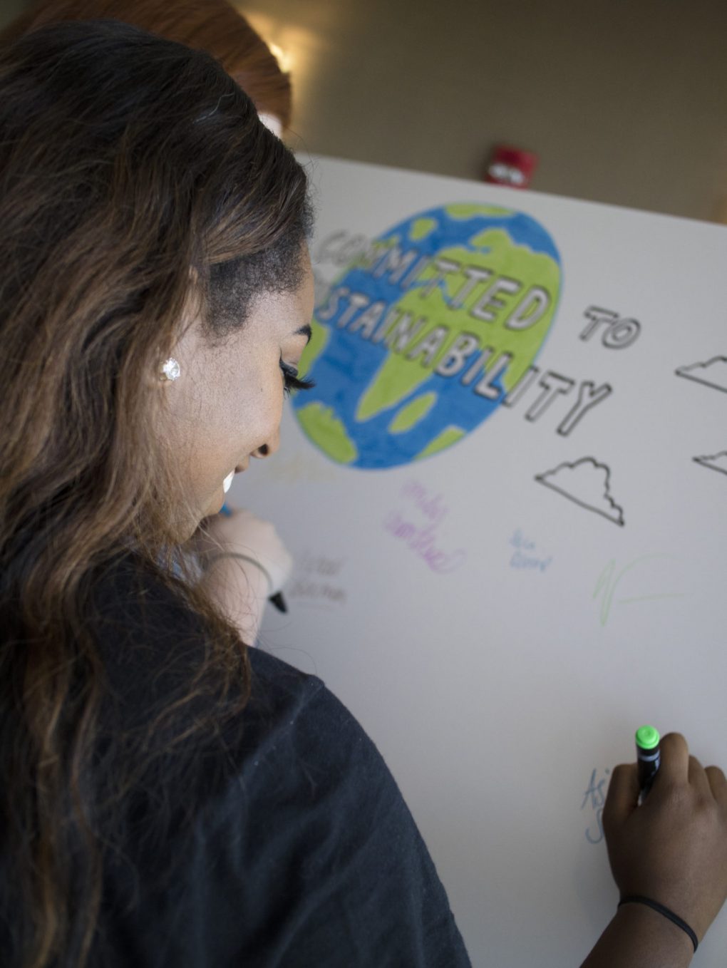 UAH's Sustainability World Café attendee signing sustainability commitment board.