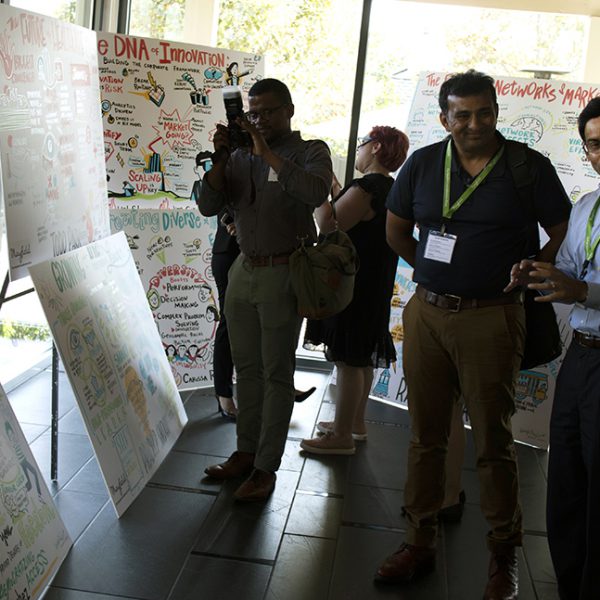 Tradeshow attendees take pictures of ImageThink graphic recording boards.