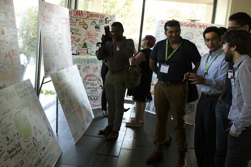 Tradeshow attendees take pictures of ImageThink graphic recording boards.