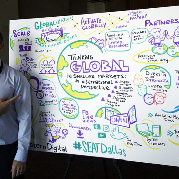 Man posing next to an infographic mural