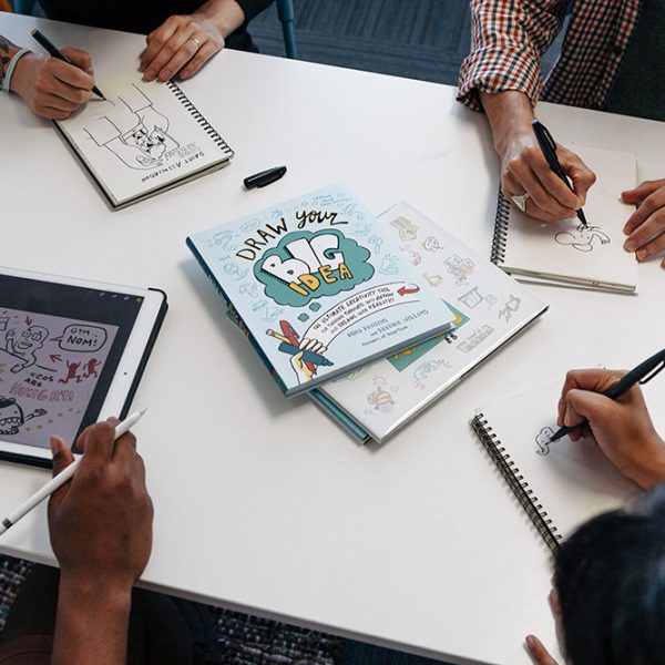 graphic recorders create sketchnotes at a desk with draw your big idea