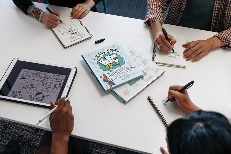 graphic recorders create sketchnotes at a desk with draw your big idea