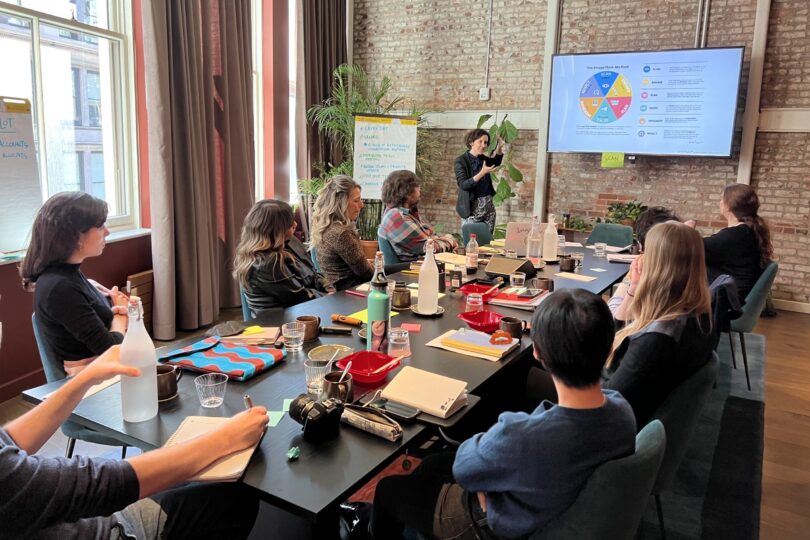 Team gathered around conference table viewing ImageThink Method on a screen