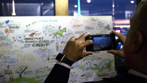 a participant takes a photo of an imagethink graphic recording.