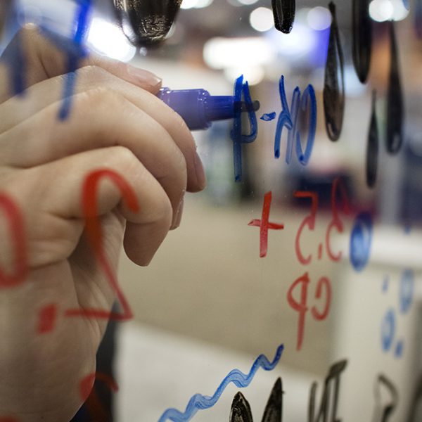 a graphic recorder from imagethink draws on a pane of glass to create an interactive conference experience