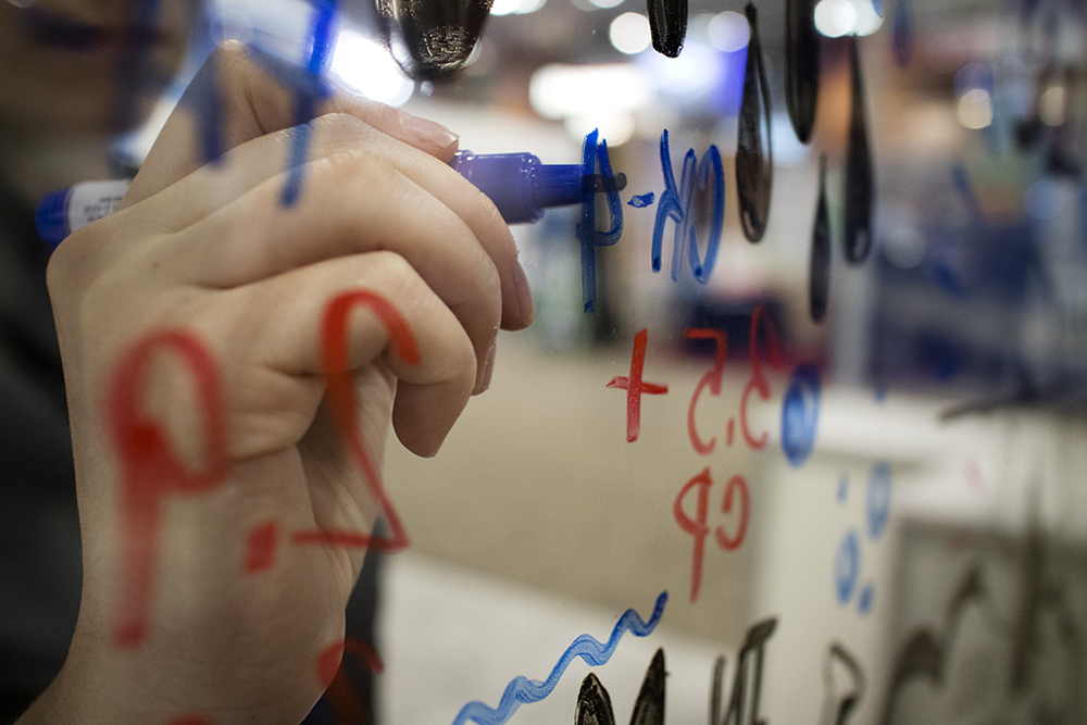 a graphic recorder from imagethink draws on a pane of glass to create an interactive conference experience