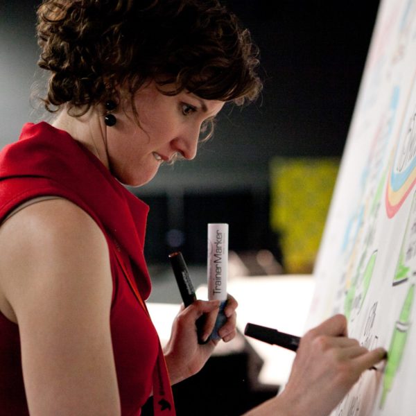 An image of ImageThink CEO Nora Herting drawing on a board.