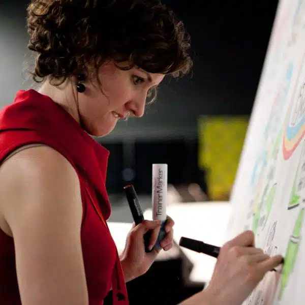 An image of ImageThink CEO Nora Herting drawing on a board.