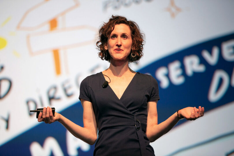 ImageThink Founder and CEO Nora Herting delivers a keynote speech in front of a large scaled graphic recording for WBENC.