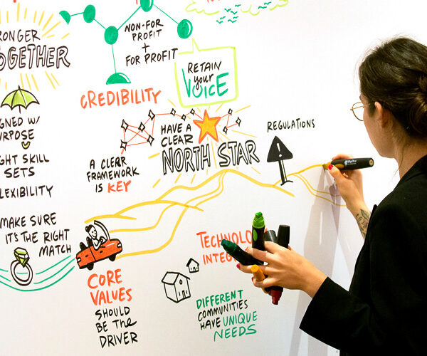 An image of an ImageThink visual strategist drawing on a board.