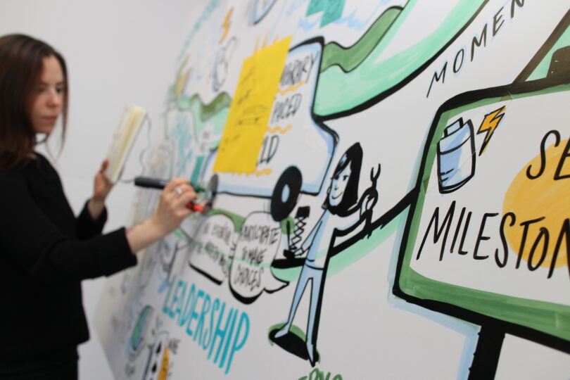 ImageThink visual strategist creates striking visuals on foam core board with marker.