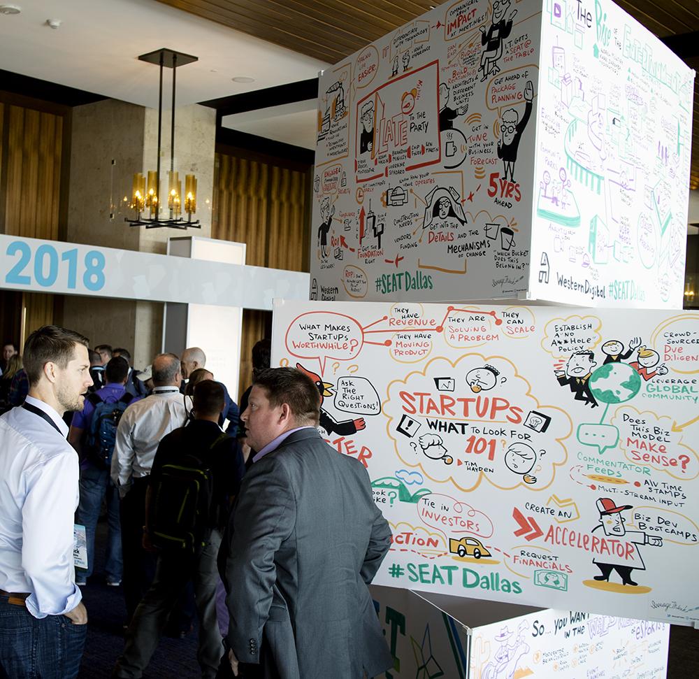 Excited attendees converse next to ImageThink's board towers.