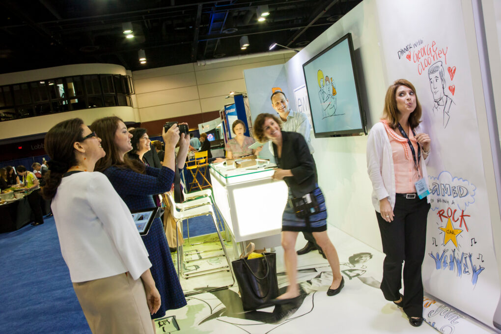 An attendee poses in front of an ImageThink social listening mural at EWI's trade show booth.