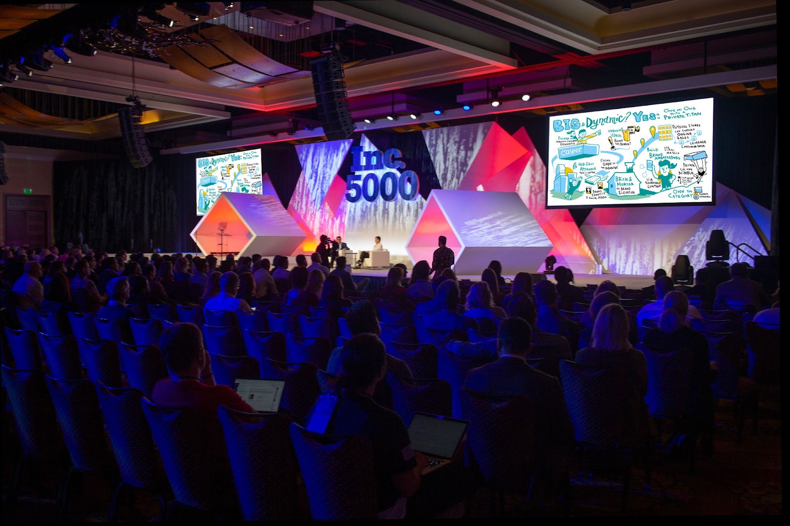 Visual presentation drawing on a stage at a larger event space.