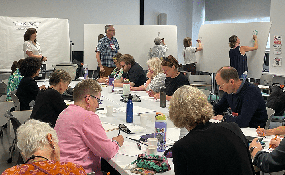 A group of people engaging in visual graphics at the 2024 Annual Conference.