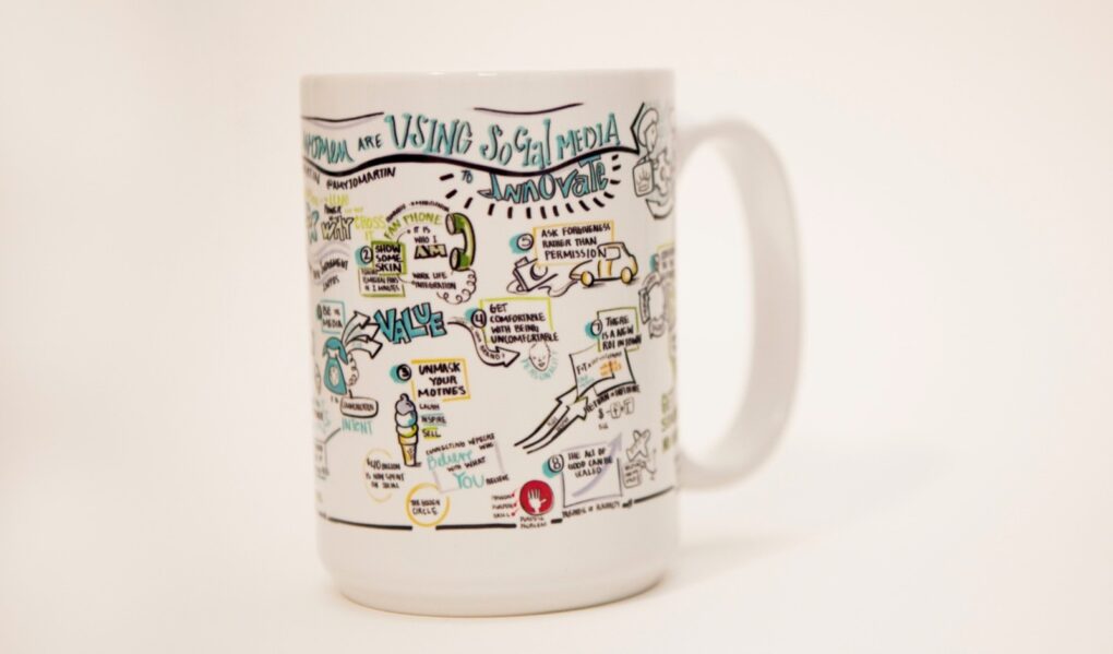 A branded mug that has been printed with visual notes for team recognition.