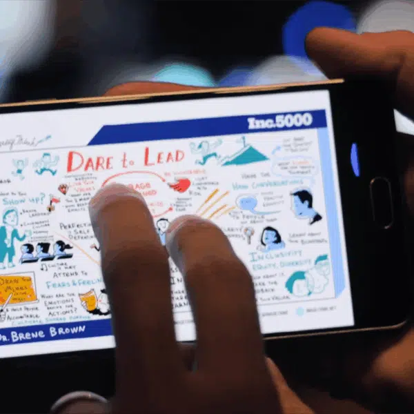 A hand holds a phone showing a nonprofit graphic recording about daring to lead.