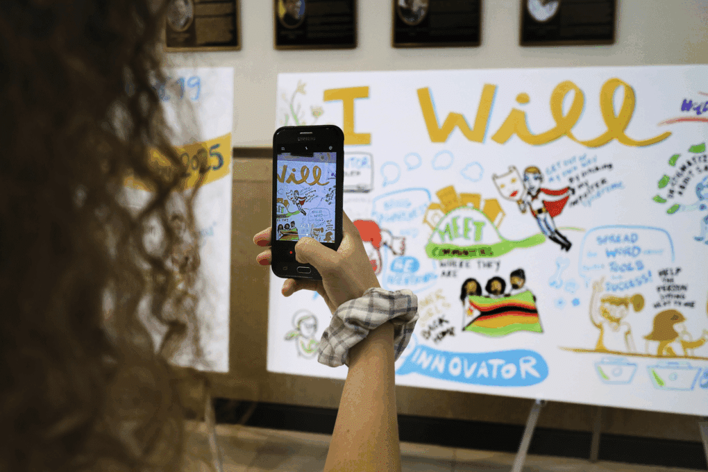 A woman taking a photo of visual notes after an event.