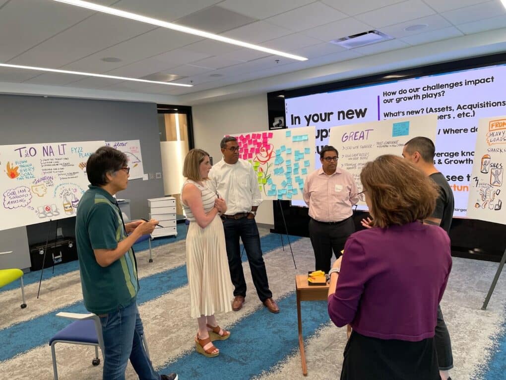 A group of people working on relationship mapping through graphic facilitation. 