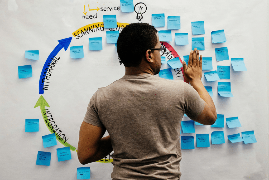 Team member organizing story ideas with sticky notes on a wall for a fundraising campaign.
