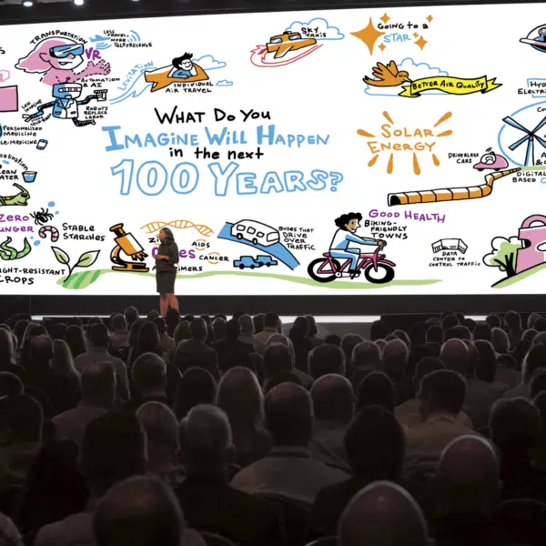 Leader speaking to audience with large scale graphic recording