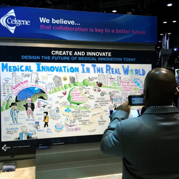 Man takes photo at Graphic recording and healthcare tradeshow booth